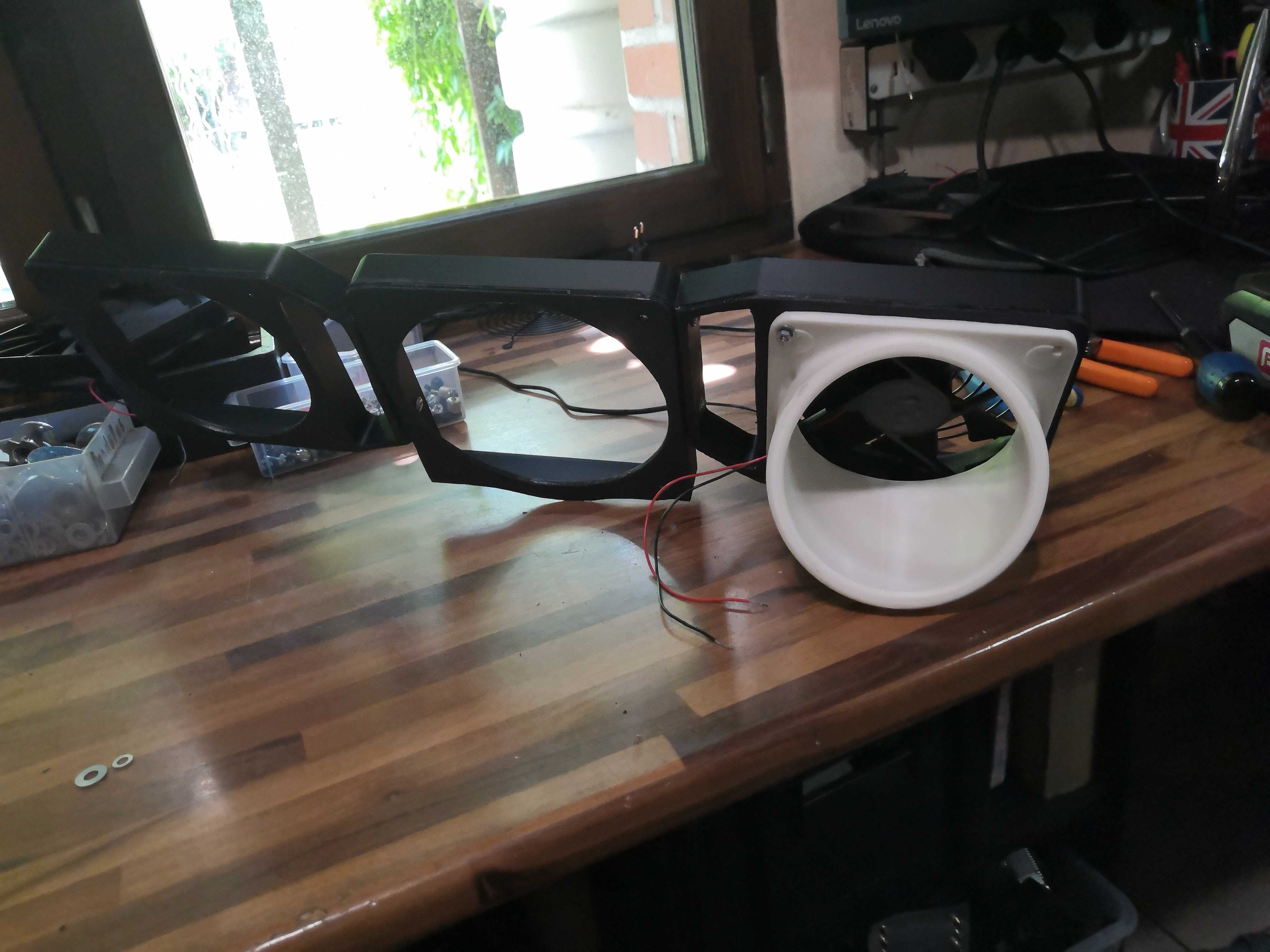 Side view: white air nozzle mounted on the bracket-and-fan assembly