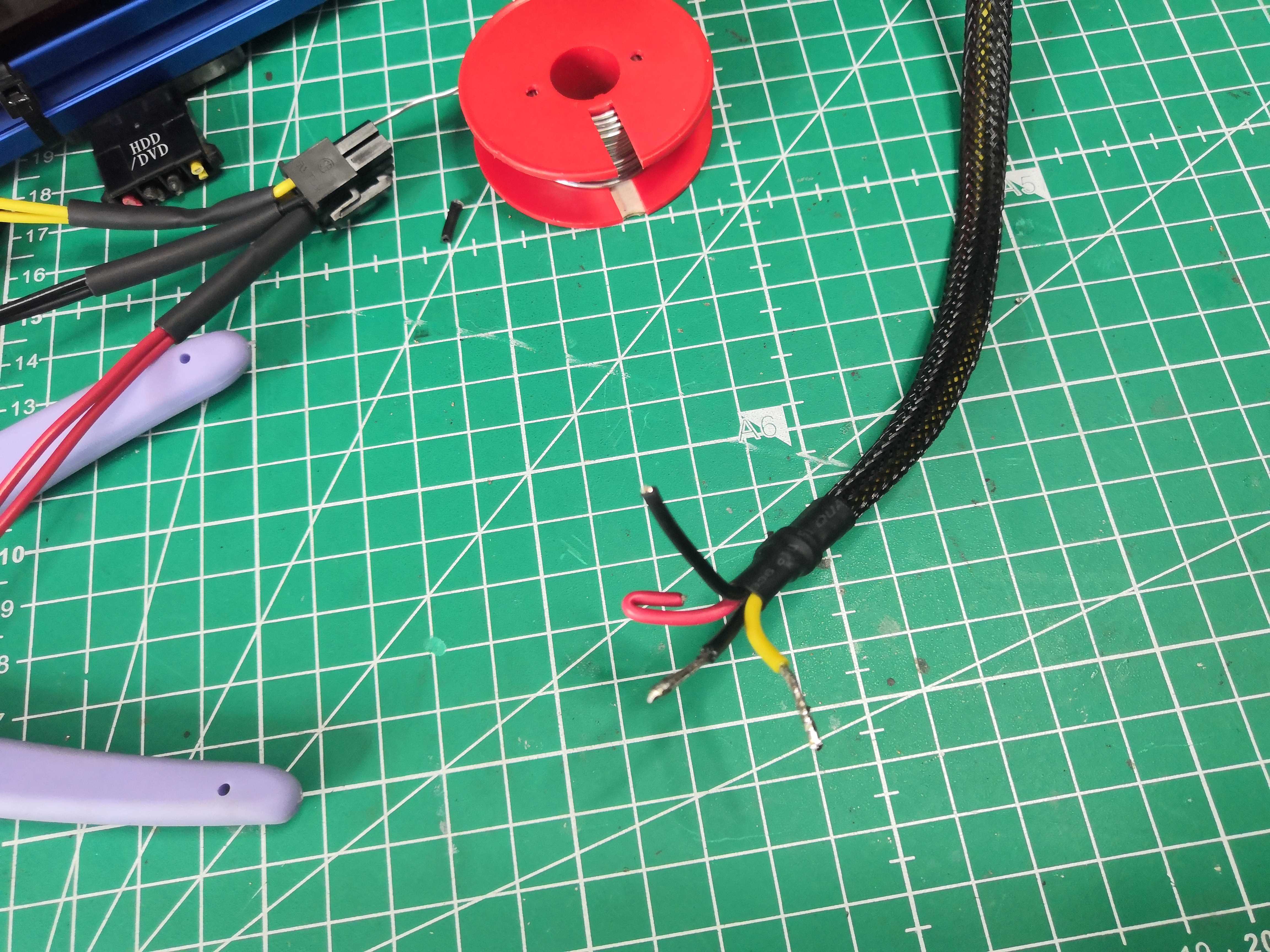 Connection in progress — clean solder joint on the 6-pin connector